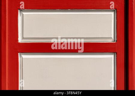 Red and white wooden panel texture showing architectural door detail. Stock Photo