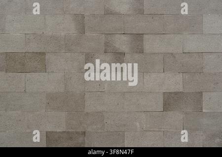 Grey rectangular stone tile wall texture in a running bond pattern background. Stock Photo