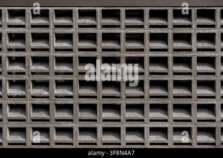 Concrete breeze block wall texture showing a repeating square grid pattern for architectural ventilation. Stock Photo