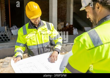 Professional builders analyzing blueprint architectural scheme Stock Photo