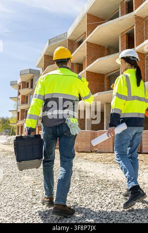 Full length back view of female architect and male engineer walking Stock Photo