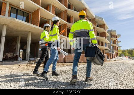 Group of diverse builders carrying tools on gravel road Stock Photo