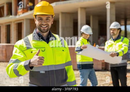 Happy male constructor showing thumb up sign Stock Photo