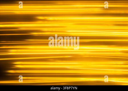 Luxurious golden metallic lines swinging from side to side creating a minimalist dynamic backdrop Stock Photo