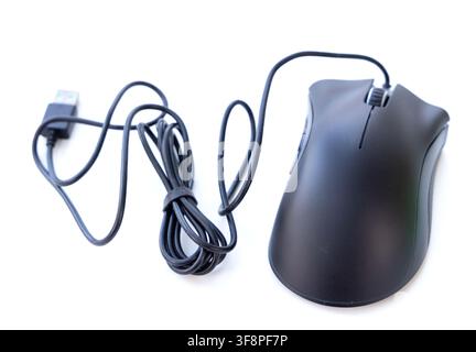 A black wired computer mouse rests on a clean white background Stock Photo