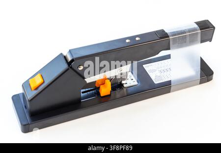A black heavy duty stapler with orange accents is shown on white Stock Photo