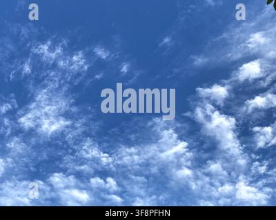 Deep blue sky with wispy white clouds Stock Photo