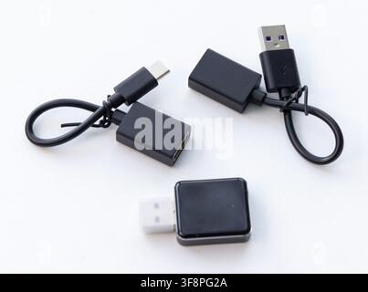 Several black USB adapters and cables are displayed on a white background Stock Photo