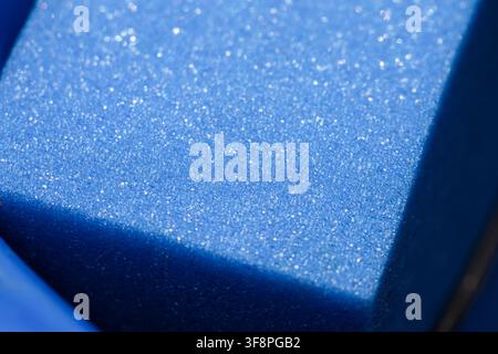 A blue makeup sponge with glittery texture and soft foam surface sparkling under light, close up beauty tool detail and cosmetic applicator mood Stock Photo