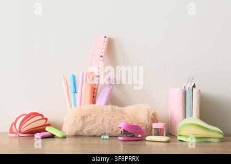 Pastel colored school supplies and office stationery on a wooden desk with a white background, back to school Stock Photo
