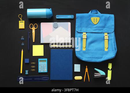 Blue backpack and school supplies flat lay on a dark background, education and back to school for students, this collection of educational items repre Stock Photo
