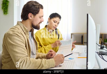 Man and woman analyzing bills and reports at computer, household budget planning Stock Photo