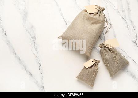 Full sacks with tags on grunge white background Stock Photo