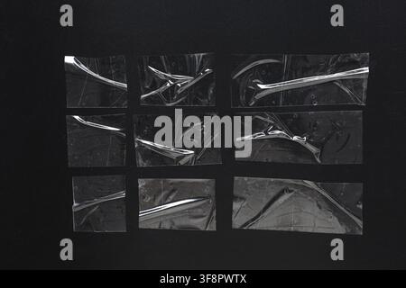 Clear adhesive tape pieces with wrinkles and air bubbles on a dark black background, abstract texture overlay Stock Photo