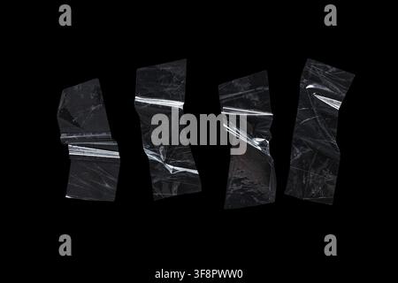 Four pieces of crumpled clear plastic wrap texture with wrinkles and reflections on a black background, the transparent material is isolated on a blac Stock Photo