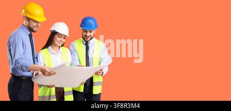 Three smiling construction engineers in hard hats and safety vests reviewing blueprints on an orange background, They are engaged in a discussion abou Stock Photo