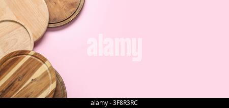 Assortment of round wooden cutting boards and serving platters on a light pink background with copy space Stock Photo