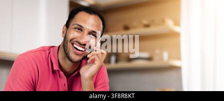 Happy Young Man Smiling While Talking On Phone At Home, Business Concept Stock Photo