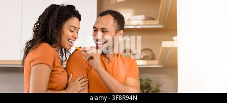 Happy Mixed Race Couple Enjoying Cooking Together In Kitchen, Love And Togetherness Concept Stock Photo