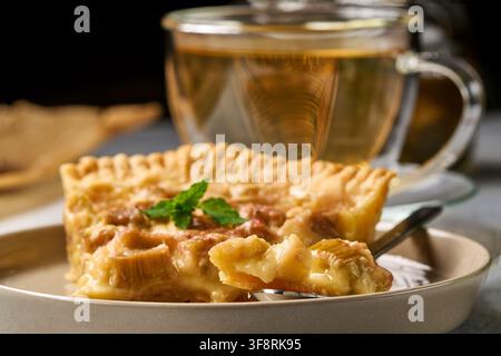 apple pie served with tea on a ceramic plate in a cozy indoor dining setting, top-down view, comforting and warm atmosphere, brown and white colors Stock Photo
