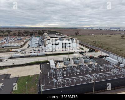 Modern data center buildings connected to a large electrical substation, showcasing digital infrastructure and power supply Stock Photo