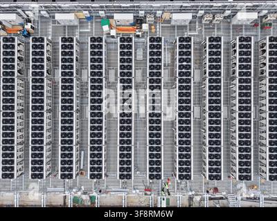 Aerial view showing rows of industrial cooling units and fans on a data center rooftop, ensuring energy efficiency and optimal performance Stock Photo