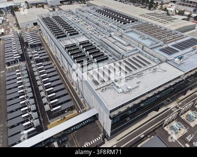 Massive data center facility with rows of cooling units, server modules, and solar panels supporting global digital infrastructure Stock Photo