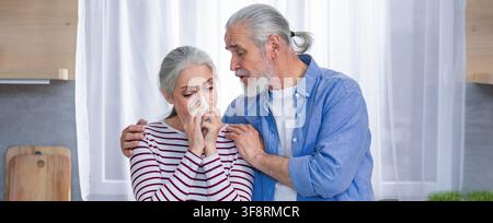 Concerned Caucasian Elderly Woman Crying Being Comforted By Senior Man In Kitchen, Emotional Support Concept Stock Photo