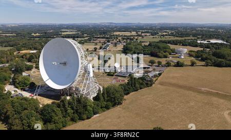 Cheshire, United Kingdom - 08 August 2026: Aerial view of the Jodrell Bank Centre for Engagement with its iconic Lovell Telescope, surrounded by green Stock Photo