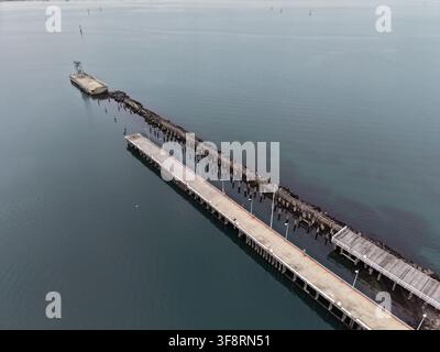 Princess pier in port phillip bay, melbourne, showing historic wooden ruins and a modern concrete pier extending over calm bay water Stock Photo