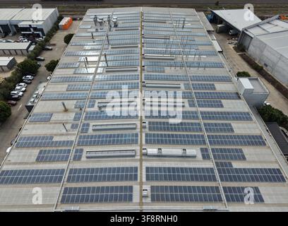 Large solar panel array generating clean energy on an industrial building roof Stock Photo