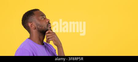 Thoughtful Black Male Considering Ideas With Hand On Chin, Profile View, Yellow Background Stock Photo