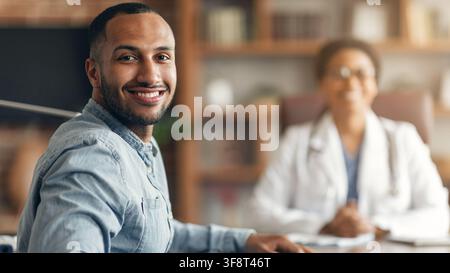 Smiling Young Black Man At Healthcare Appointment In Office, Healthcare Concept Stock Photo