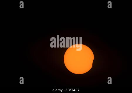 Partial solar eclipse viewed from Epsom Downs, Surrey, England, on the evening of 12 August 2026, showing the Moon obscuring the upper-right portion o Stock Photo