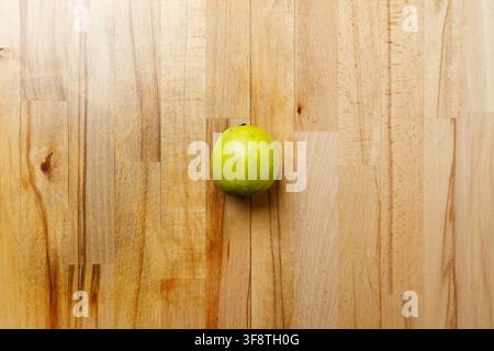 Single whole green lime on wooden table background Stock Photo
