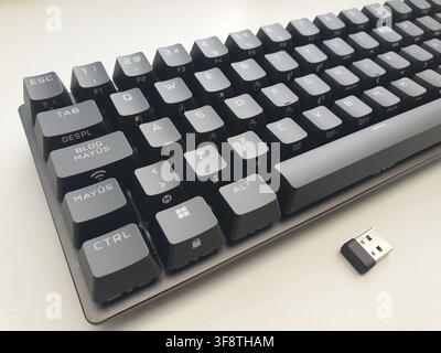 A compact wireless computer keyboard and its USB receiver are visible Stock Photo