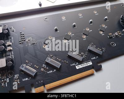 A black M2 NVMe SSD expansion card lies on a white surface Stock Photo