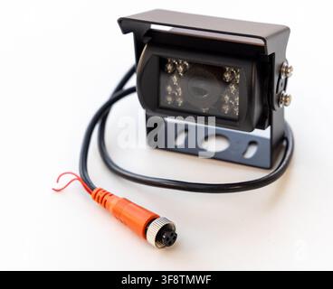 A black vehicle backup camera with an orange connector is on white Stock Photo
