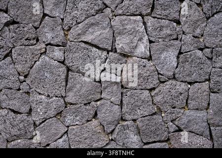 MOUNT BATUR, BALI, INDONESIA — March 26, 2026: Detailed view of a wall assembled from irregular pieces of porous volcanic stone in the Batur region. Stock Photo