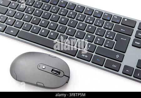 A black wireless keyboard and mouse rest on a white surface Stock Photo