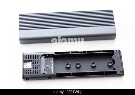 A black disassembled NVMe SSD enclosure is shown on a white background Stock Photo