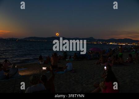 The total solar eclipse glows above the darkened waters off Mallorca on August 12, 2026, spectators watches from the beach under deepdeep blue twiligt Stock Photo