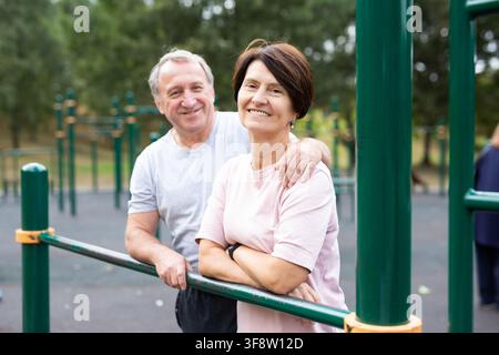 Elderly man and woman posing in open-air sports bars complex Stock Photo