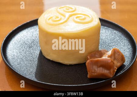 Creamy golden French handmade on farm butter from Brittany and caramel candies with sea salt flavor. Premium artisanal dairy product of Brittany. Stock Photo