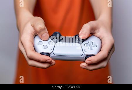 Gamer hand using video game console controller. Playing games concept. Man play a football game with video game controller. Child holding a game Stock Photo
