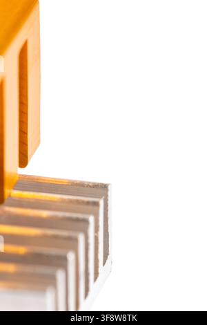 Orange tool rests beside metallic fins. White background highlights sharp geometric forms. Industrial precision is subtly implied. Ideal for tech, eng Stock Photo