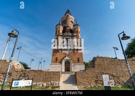 A wide-angle view of the historic Gardos Millennium Tower standing behind brick ruins in Zemun, Belgrade, Serbia. The brick and stone monument rises a Stock Photo