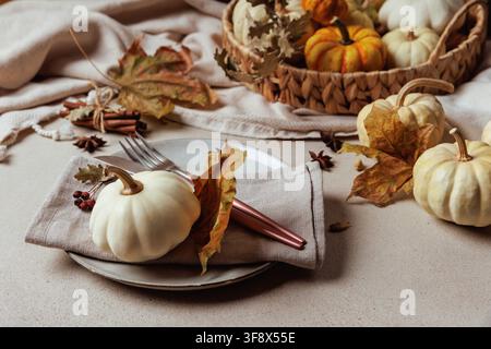 Autumn plate setting with pumpkin and leaves on fabric.. Stock Photo