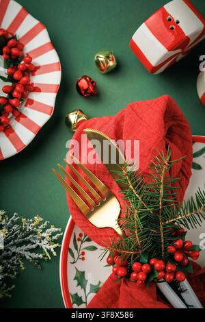 Vertical Christmas Place Setting with Gold Cutlery and Festive Holiday Decor Stock Photo