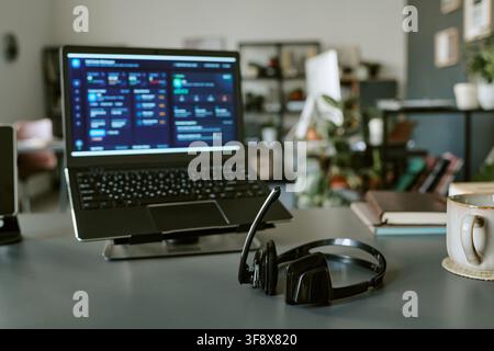 Headset on Desk with Laptop Displaying Customer Support Dashboard Stock Photo